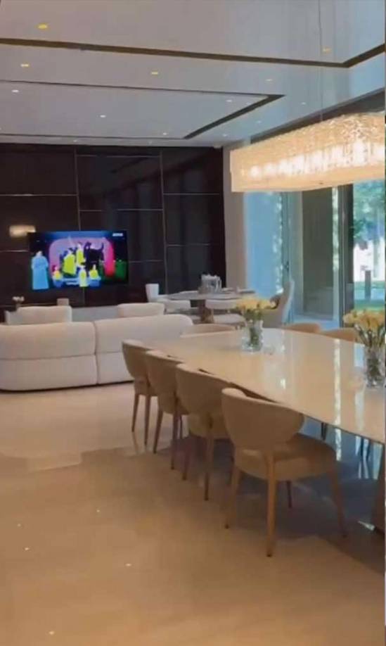 Al fondo del comedor se puede ver un sofá blanco (algo arriesgado viviendo 5 hijos en esa casa) y una gran televisión...