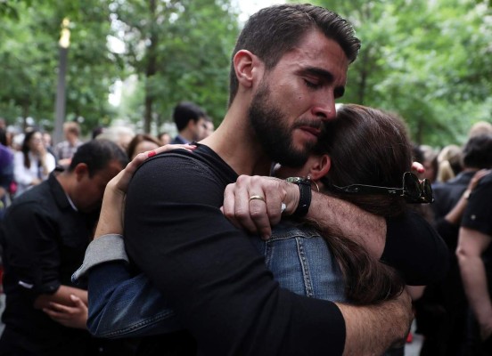 NEW YORK, NY - JUNE 16: People embrace after tying ribbons on the Survivor Tree at the National September 11 Memorial & Museum in honor of the victims of the Orlando nightclub attack on June 16, 2016 in New York City. Hundreds of people tied colored ribbons on the Survivor Tree at the National September 11 Memorial & Museum to honor the victims of the terror attack at the Pulse nightclub in Orlando over the weekend that left 49 dead. Justin Sullivan/Getty Images/AFP== FOR NEWSPAPERS, INTERNET, TELCOS & TELEVISION USE ONLY ==