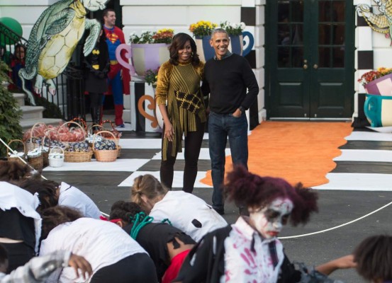 US President Barack Obama and First Lady Michelle Obama watch children perform Michael Jackson'n Thriller on the South Lawn of the White House during a Halloween event in Washington, DC, on October 31, 2016. / AFP PHOTO / NICHOLAS KAMM