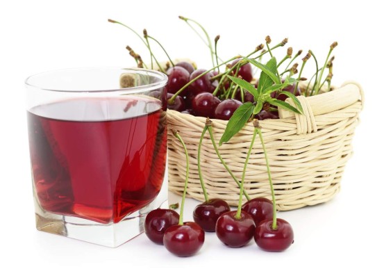 Cherries and a glass of cherry juice isolated on white