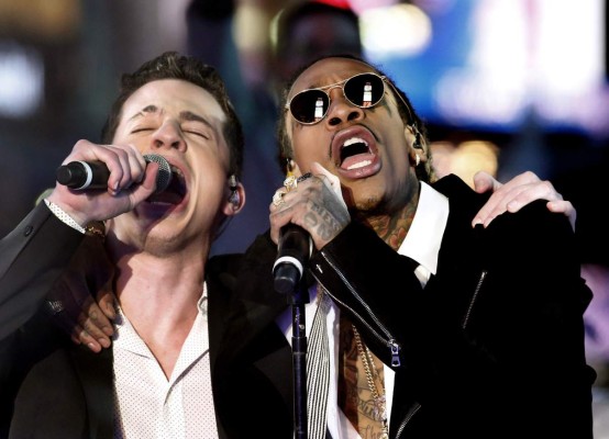 (FILES) This file photo taken on December 31, 2015 shows singers Wiz Khalifa (R) and Charlie Puth performing during a New Year's Eve event in Times Square in New York. 'Gangnam Style,' the quirky South Korean video that spawned a global dance craze and went so viral it nearly broke YouTube, has finally been dethroned as the most watched video. After four and a half years as YouTube's most seen video, 'Gangnam Style' slipped late July 10, 2017, to number two, replaced by 'See You Again' by Wiz Khalifa and Charlie Puth. / AFP PHOTO / KENA BETANCUR