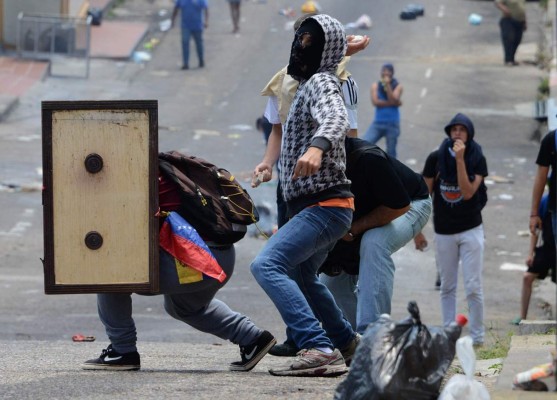 Venezuelan opposition activists clash with the police during a demonstration in San Cristobal, on May 11, 2016.Thousands of Venezuelan opposition took to the streets to demand the National Electoral Council (CNE) to accelerate the process of a recall referendum against President Nicolas Maduro. / AFP PHOTO / George Castellanos