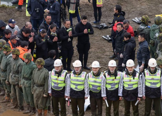 Catalan regional police 'Mossos D'Esquadra' officers stand guard stand guard as garbage containers burn outside the Camp Nou stadium in Barcelona on December 18, 2019, prior to the 'El Clasico' Spanish League football match between Barcelona FC and Real Madrid CF. (Photo by Pau Barrena / AFP)