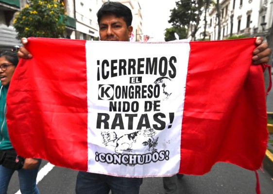 A demonstrator marches against corruption in Lima on September 30, 2019 after President Martin Vizcarra constitutionally dissolved the Congress, dominated by the opposition, after it refused to suspend a controversial appointment of new members of the Constitutional Court. - Vizcarra had originally threatened to dissolve Congress and force new legislative elections in June, unless lawmakers backed his anti-graft proposals. The proposal to lift legislative immunity turned into the source of the latest conflict between Peru's executive and legislative branches; Vizcarra proposed giving the Supreme Court power to decide whether to strip a legislator of the protection. Congress, which currently holds the power to lift judicial immunity, rejected the idea. (Photo by Cris BOURONCLE / AFP)