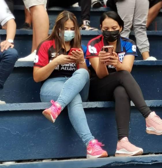 Estas aficionadas del Olimpia, entretenidas con sus celulares antes del inicio del partido.
