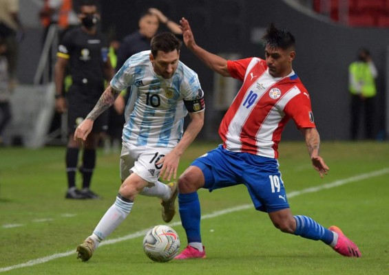 Argentina's Lionel Messi (L) and Paraguay's Santiago Arzamendia vie for the ball during their Conmebol Copa America 2021 football tournament group phase match at the Mane Garrincha Stadium in Brasilia on June 21, 2021. (Photo by NELSON ALMEIDA / AFP)