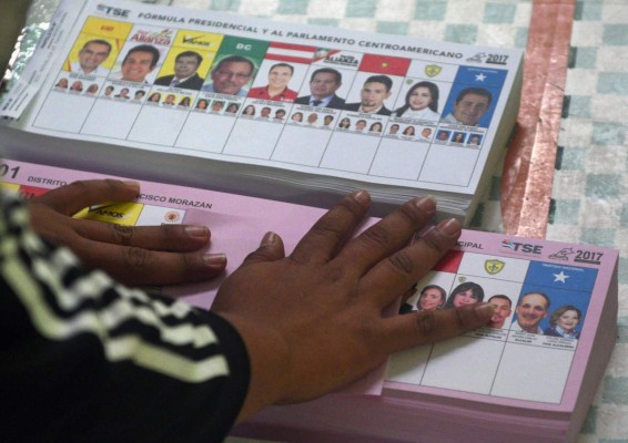 Election officials work at a polling station in Tegucigalpa during the general election on November 26, 2017. Honduras' six million voters are to cast ballots in a controversial election Sunday in which President Juan Orlando Hernandez is seeking a second mandate despite a constitutional one-term limit. This small country is at the heart of Central America's 'triangle of death,' an area plagued by gangs and poverty. / AFP PHOTO / RODRIGO ARANGUA