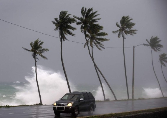 -FOTODELDÍA- STO82. SANTO DOMINGO (REPÚBLICA DOMINICANA), 21/09/2017.- Un vehículo transita cerca a la playa que presenta oleaje fuerte hoy, jueves 21 de septiembre de 2017, tras el paso del huracán María en Santo Domingo (República Dominicana). Las autoridades de socorro dominicanas advirtieron hoy que 'lo peor aún no ha pasado' con relación a los efectos del huracán María, que ha dejado 25 comunidades incomunicadas y ha provocado el desplazamiento de 16.727 personas. EFE/Orlando Barría
