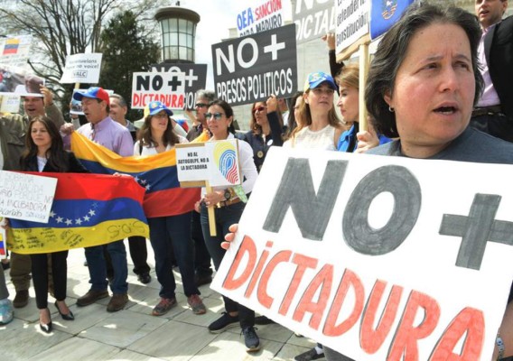 TOPSHOT - Anti-government activists clash with riot police during a protest in Caracas on July 28, 2017. Protesters took over streets in Caracas on Friday in a show of defiance to President Nicolas Maduro, as the crisis gripping Venezuela turned deadlier ahead of a controversial weekend election that has earned international scorn. / AFP PHOTO / RONALDO SCHEMIDT