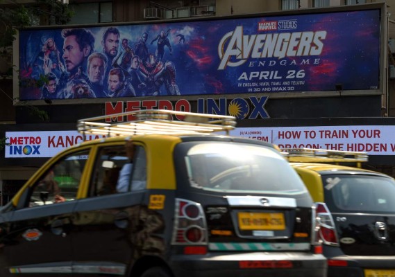 Indian vehicles go past a movie theatre displaying a poster of the latest Avengers movie, in Mumbai on April 25, 2019. - Marvel's 'Avengers: Endgame' the latest superhero movie smashed all time Indian records with over 2.5 million advance ticket bookings surpassing other Hollywood and Bollywood films. (Photo by Indranil MUKHERJEE / AFP)