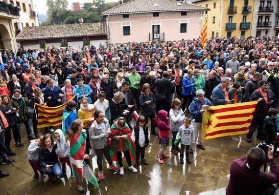 People hold Catalan pro-independence Estelada flags and Basque Country flags during a demonstration in the northern Spain Basque village of Beasain on October 22, 2017 during a protest action organized by 'Gure esku dago' (It's in our hands) association supporting the right for a referendum on self determination in Catalonia. / AFP PHOTO / ANDER GILLENEA