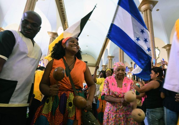 Garifuna women dance as they enter the Basilica of Suyapa in Tegucigalpa, on the 272nds anniversary of the finding of the statue of the Virgin of Suyapa, the patron saint of Honduras, on February 02, 2019. - Thousands of pilgrims prayed on Saturday to the virgin of Suyapa, patron saint of Honduras, asking for security and social equality, in an annual celebration in which about two million faithfuls take part during ten days. (Photo by ORLANDO SIERRA / AFP)