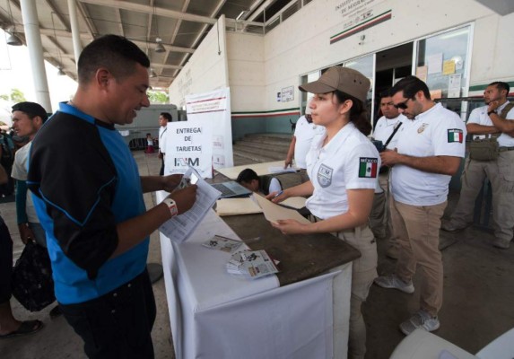 Central American migrants heading to the United States with a second caravan receive their visitor's card for Humanitarian Reasons from immigration officials, in Ciudad Hidalgo, Chiapas state, southern Mexico on January 21, 2019. - Hundreds of Central Americans entered Mexico illegally as the latest migrant caravan trying to reach the United States began crossing the Mexican-Guatemalan border en masse Friday. (Photo by ALEJANDRO MELENDEZ / AFP)