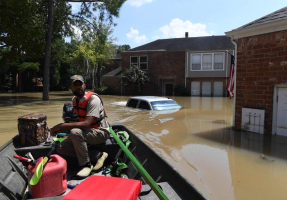 Volunteer rescuer Matt Clarke searches for local residents after a mandatory evacuation was ordered in the area beneath the Barker Reservoir as water is released, after Hurricane Harvey caused widespread flooding in Houston, Texas on August 31, 2017.Hurricane Harvey hit the Texas coast with over 3 feet of rain and 125 mph winds. / AFP PHOTO / MARK RALSTON