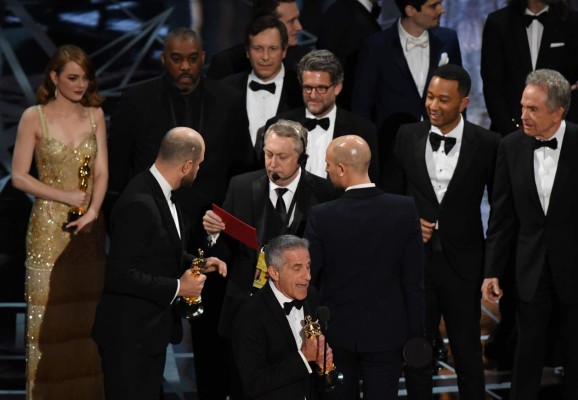 TOPSHOT - 'La La Land' producer Jordan Horowitz (2L) speaks to stage manager Gary Natoli (C), reading the winners card, after 'La La Land' mistakenly won the best picture instead of 'Moonlight' at the 89th Oscars on February 26, 2017 in Hollywood, California. / AFP PHOTO / Mark RALSTON