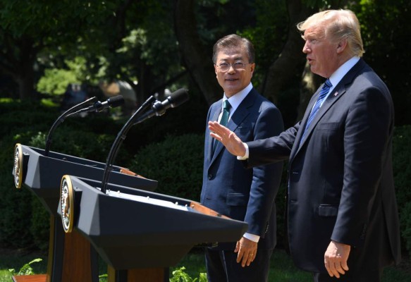 US President Donald Trump gestures as South Korean President Moon Jae-in looks on after a joint press conference in the Rose Garden at the White House in Washington, DC, on June 30, 2017. / AFP PHOTO / JIM WATSON