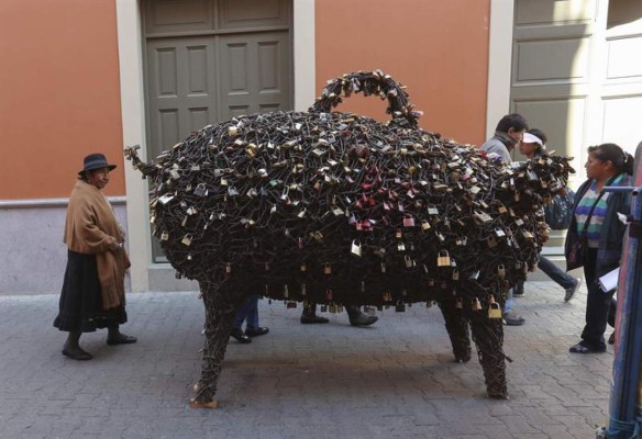 Cerdito de la fortuna boliviano atrae candados del amor puestos en puentes  
