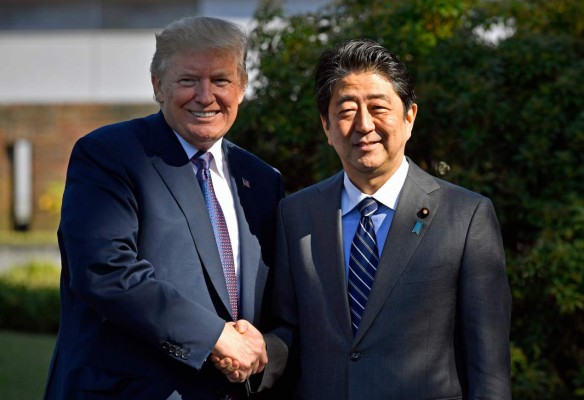 US President Donald Trump (L) shakes hands with Japanese Prime Minister Shinzo Abe upon his arrival at the Kasumigaseki Country Club in Kawagoe, near Tokyo on November 5, 2017. Trump touched down in Japan, kicking off the first leg of a high-stakes Asia tour set to be dominated by soaring tensions with nuclear-armed North Korea. / AFP PHOTO / POOL / FRANCK ROBICHON