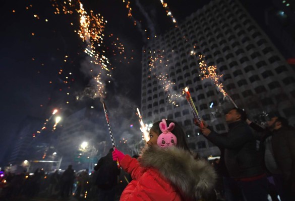 People celebrate during a countdown event to mark the New Year in downtown Seoul on January 1, 2017. / AFP PHOTO / JUNG Yeon-Je