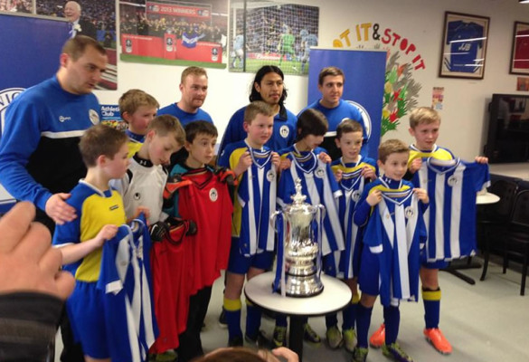 Roger Espinoza visita a niños campeones de Wigan