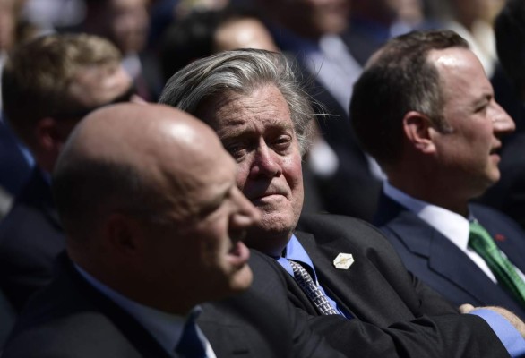 White House Chief Strategist Steve Bannon listens as US President Donald Trump leaves after announcing his decision to withdraw the US from the Paris Climate Accords in the Rose Garden of the White House in Washington, DC, on June 1, 2017. 'As of today, the United States will cease all implementation of the non-binding Paris accord and the draconian financial and economic burdens the agreement imposes on our country,' Trump said. / AFP PHOTO / Brendan Smialowski