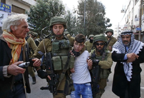 Israeli security forces arrest Palestinian protesters during clashes in the city centre of the occupied West Bank town of Hebron on December 15, 2017 as demonstrations continue to flare in the Middle East and elsewhere over US President Donald Trump's declaration of Jerusalem as Israel's capital. / AFP PHOTO / HAZEM BADER