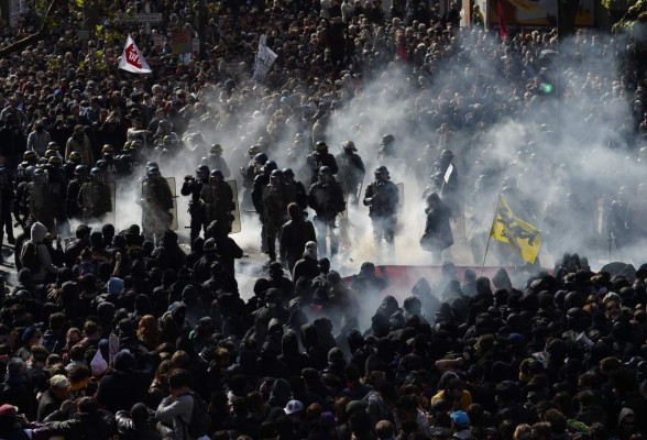 Protesters throw a smoke grenades towards French anti riot police during a clash during the traditional May Day demonstration in Paris on May 1, 2016. AFP PHOTO / ALAIN JOCARD / AFP PHOTO / ALAIN JOCARD