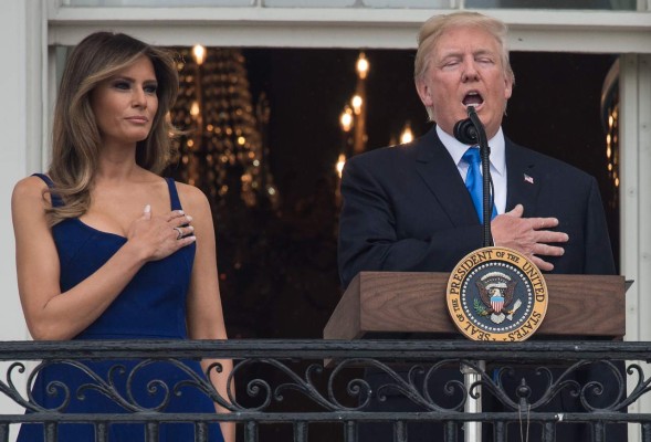 US President Donald Trump sings the national anthem next to First Lady Melania Trump during the military families picnic at the White House in Washington, DC, on July 4, 2017. / AFP PHOTO / NICHOLAS KAMM