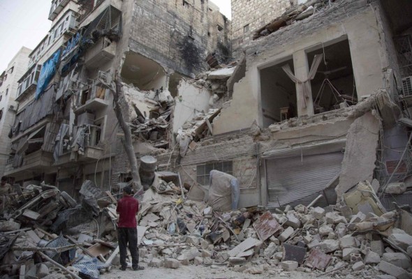 A syrian man stands next to the debris outside a building hit by overnight shelling in Aleppo's rebel-held Qasr al-Bustan neighbourhood on June 9, 2016.Government bombardment of eastern Aleppo on June 8 hit within a few hundred metres (yards) of three medical facilities, including near Al-Hakim and near the Al-Bayan hospital, leaving at least 15 civilians dead. / AFP PHOTO / KARAM AL-MASRI
