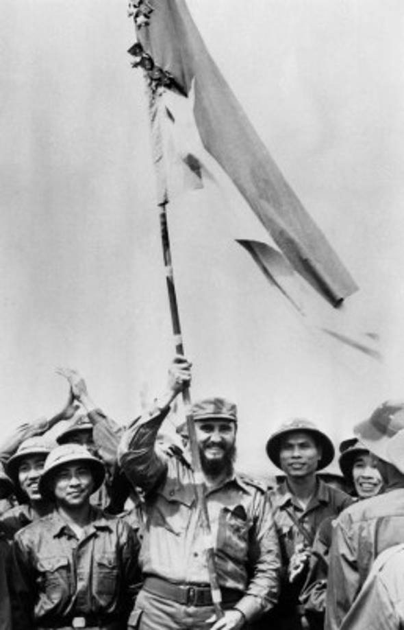 Fidel Castro con una bandera durante su visita en Vietnam del Sur durante la guerra de Vietnam, en septiembre de 1973. AFP