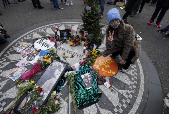 A woman gestures as mourners gather on the 40th anniversary of John Lennon's death, at Strawberry Fields, in Central Park to honor the late Beatles star in New York on December 8, 2020. (Photo by TIMOTHY A. CLARY / AFP)