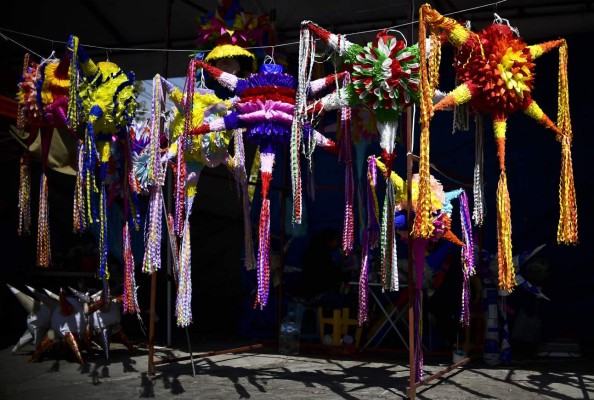 Traditional Mexican pinatas are displayed for sale at a market in Acolman, Mexico state, on December 18, 2017. The pinata -a papier mache party decoration filled with candy that is hung up at parties and struck with a stick until it breaks open- is a central element of the Mexican Christmas holidays, forming part of a deep-rooted tradition that mixes indigenous customs and the evangelising zeal of the Augustinians in the sixteenth century. / AFP PHOTO / RONALDO SCHEMIDT / TO GO WITH AFP STORY by YEMELI ORTEGA