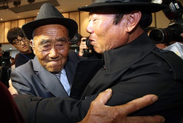 North Korean Oh In-Se (L), 83, meets with his son Oh Jang-Gyun (R) during a separated family reunion meeting at the Mount Kumgang resort on the North's southeastern coast on October 20, 2015. Nearly 400 mostly elderly and frail South Koreans began a tearful, emotionally fraught reunion with family members in North Korea, more than 60 years after they were separated by the Korean War. REPUBLIC OF KOREA OUT AFP PHOTO / POOL / The Korea Press Photographers Association