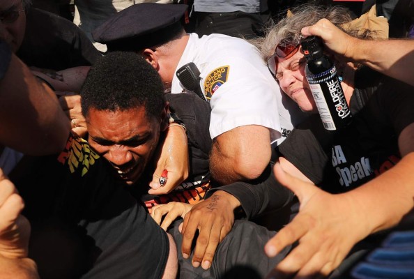 CLEVELAND, OH - JULY 20: Protesters struggle with police after trying to burn an American Flag near the sight of the Republican National Convention (RNC) in downtown Cleveland on the third day of the convention on July 20, 2016 in Cleveland, Ohio. Many people have stayed away from downtown due to road closures and the fear of violence. An estimated 50,000 people are expected in Cleveland, including hundreds of protesters and members of the media. The four-day Republican National Convention kicked off on July 18. Spencer Platt/Getty Images/AFP== FOR NEWSPAPERS, INTERNET, TELCOS & TELEVISION USE ONLY ==