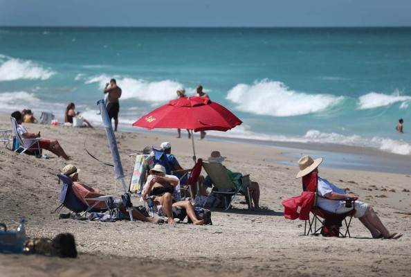 JENSEN BEACH, FLORIDA - MAY 04: Beach goers enjoy the weather on May 04, 2020 in Jensen Beach, Florida. Restaurants, retailers, as well as beaches and some state parks reopened today with caveats, as the state continues to ease restrictions put in place to contain COVID-19. The counties of Palm Beach, Broward and Miami Dade continue to maintain restrictions. Joe Raedle/Getty Images/AFP== FOR NEWSPAPERS, INTERNET, TELCOS & TELEVISION USE ONLY ==