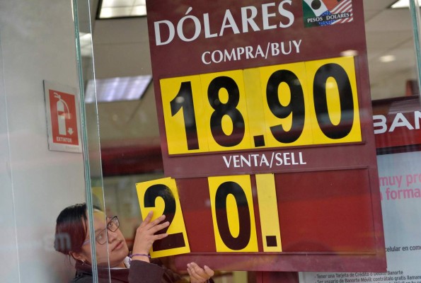 The US dollar exchange rate is seen on the board of a bank in Mexico City on November 9, 2016. The dollar tumbled against the yen and euro while the Mexican peso fell off a cliff as polling results in the knife-edge US presidential race pointed to a strong showing by Donald Trump. / AFP PHOTO / PEDRO PARDO