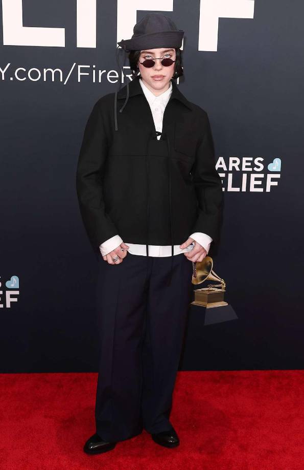 <b>Billie Eilish </b>llevó un conjunto de estilo relajado y unisex, compuesto por una chaqueta negra de corte holgado sobre una camisa blanca que se asomaba en los puños y el dobladillo. Jorge Rey, destacó: “Me parece interesante la idea de <b>llevar prendas del street a la red carpet. </b>La cadena le da el look <b>rocker,</b> le queda muy bien”.