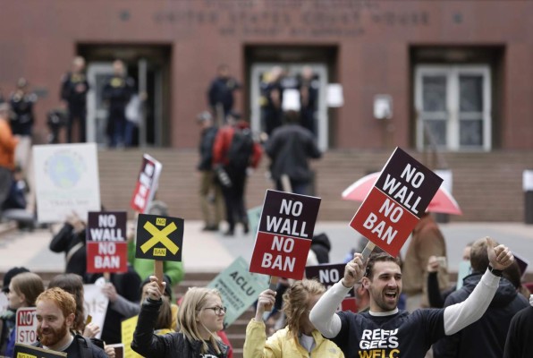 People protest outside as the 9th U.S. Circuit Court of Appeals prepares to hear arguments on President Trump's revised travel ban in Seattle on Monday.
