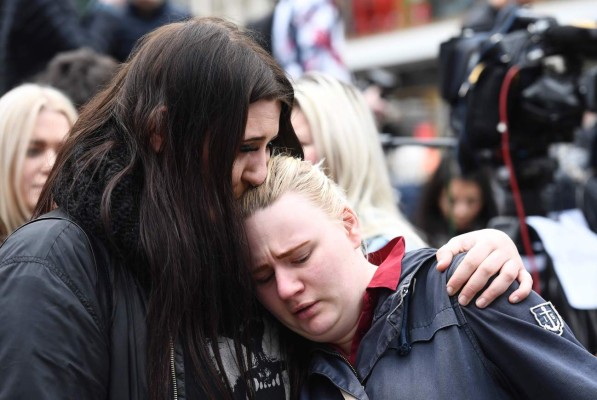 People react at a makeshift memorial near the site where a truck slammed into a crowd yesterday outside a busy department store, in central Stockholm, on April 8, 2017. / AFP PHOTO / Jonathan NACKSTRAND