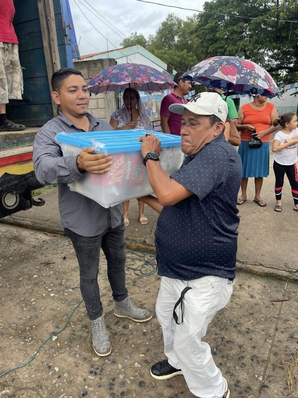 César Galo (de gris), precandidato a la alcaldía de Alianza por parte de Libre, mientras entregaba ayudas a afectados por las lluvias.
