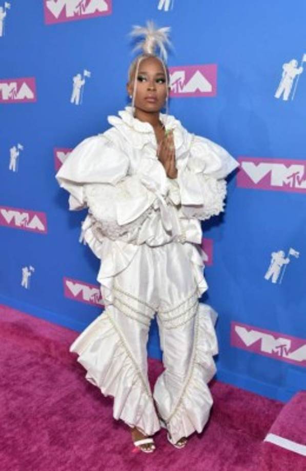 La rapera DeJ Loaf se perdió entre los vuelos de su vestido blanco, pero gracias a su peinado pudieron encontrarla entre tanta tela.<br/>
