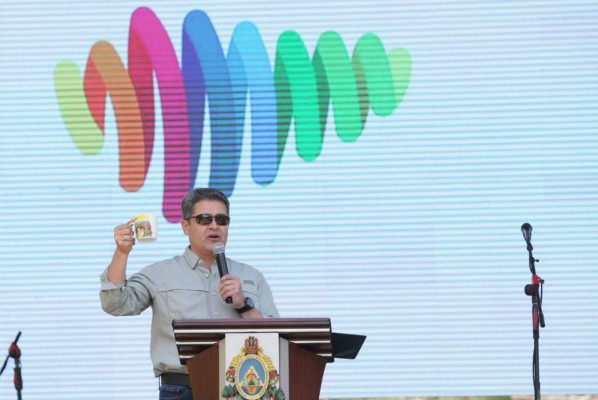 El presidente hondureño Juan Orlando Hernández Alvarado con la imagen de fondo que representa la 'Marca País Honduras'.