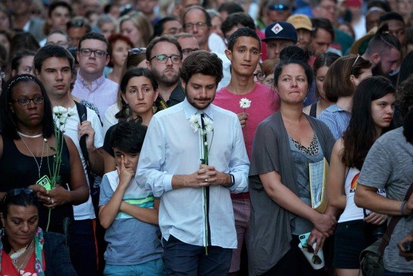 CHARLOTTESVILLE, VA - AUGUST 13: Hundreds of people gather at an informal memorial on the spot where 32-year-old Heather Heyer was killed when a car plowed into a crowd of people protesting against the white supremacist Unite the Right rally August 13, 2017 in Charlottesville, Virginia. Charlottesville is calm the day after violence errupted around the Unite the Right rally, a gathering of white nationalists, neo-Nazis, the Ku Klux Klan and members of the 'alt-right,' that left Heyer dead and injured 19 others. Win McNamee/Getty Images/AFP