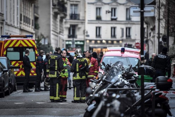 Firefighters are gathered near a building that caught fire in the 16th arrondissement in Paris, on February 5, 2019. - Seven people died and another was seriously injured in a building fire in a wealthy Paris neighbourhood overnight, the fire service said. The blaze in the French capital's trendy 16th arrondissement also left 27 people -- including three firefighters -- with minor injuries. . (Photo by STEPHANE DE SAKUTIN / AFP)