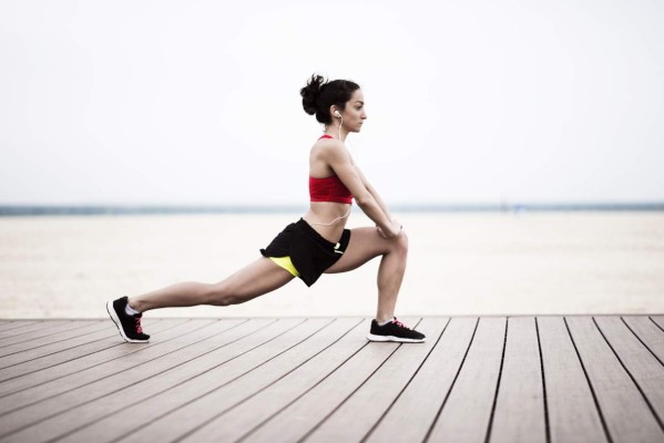 Young woman stretching on the beach, Dubai, Jumeirah Beach