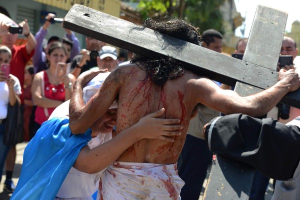 Catholic devotees perform in a Via Crucis reenactment in Trinidad, Santa Barbara department, 280 km north of Tegucigalpa on March 25, 2016. Christian believers around the world mark the Holy Week of Easter in celebration of the crucifixion and resurrection of Jesus Christ. AFP PHOTO / ORLANDO SIERRA