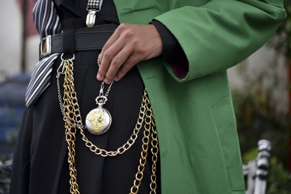 A Pachuco wearing traditional accessories is pictured at the Cultural Poliforum Carranza square in Mexico City on August 27, 2017.Wearing their feathered hats, colorful tank tops, gold chains on the lapel and patent leather shoes, the Pachucos - the subculture that characterized Mexican gangs set up in the United States in the 1940s - continue to dance to the rhythm of legendary mambo Salons in Mexico. / AFP PHOTO / YURI CORTEZ / TO GO WITH AFP STORY by YEMELI ORTEGA