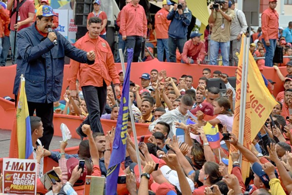 Venezuelan president Nicolas Maduro (C) greets supporters during a march to mark International Workers' Day, in Caracas on May 1, 2016. / AFP PHOTO / JUAN BARRETO