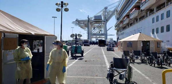 This handout photo released by Carolyn Wright, shows medical workers on the dock waiting to direct passengers disembarking from the Grand Princess cruise ship, in Oakland, California on March 11, 2020. - The Grand Princess arrived at a sealed-off wharf at the port of Oakland in San Francisco Bay on March 9 after days stranded at sea with 21 confirmed infections on board. Passengers waiting to disembark from a coronavirus-hit cruise ship in California faced frustrating delays March 10, despite US President Donald Trump saying the operation was going 'incredibly well.' (Photo by Handout / CAROLYN WRIGHT / AFP) / RESTRICTED TO EDITORIAL USE - MANDATORY CREDIT 'AFP PHOTO / CAROLYN WRIGHT ' - NO MARKETING NO ADVERTISING CAMPAIGNS - DISTRIBUTED AS A SERVICE TO CLIENTS