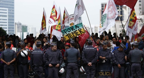 Supporters of suspended Brazilian President Dilma Rousseff hold a sign reading 'Temer out!' in a protest against interim President Michel Temer on Paulista Avenue, Sao Paulo, Brazil on August 9, 2016. / AFP PHOTO / Miguel SCHINCARIOL
